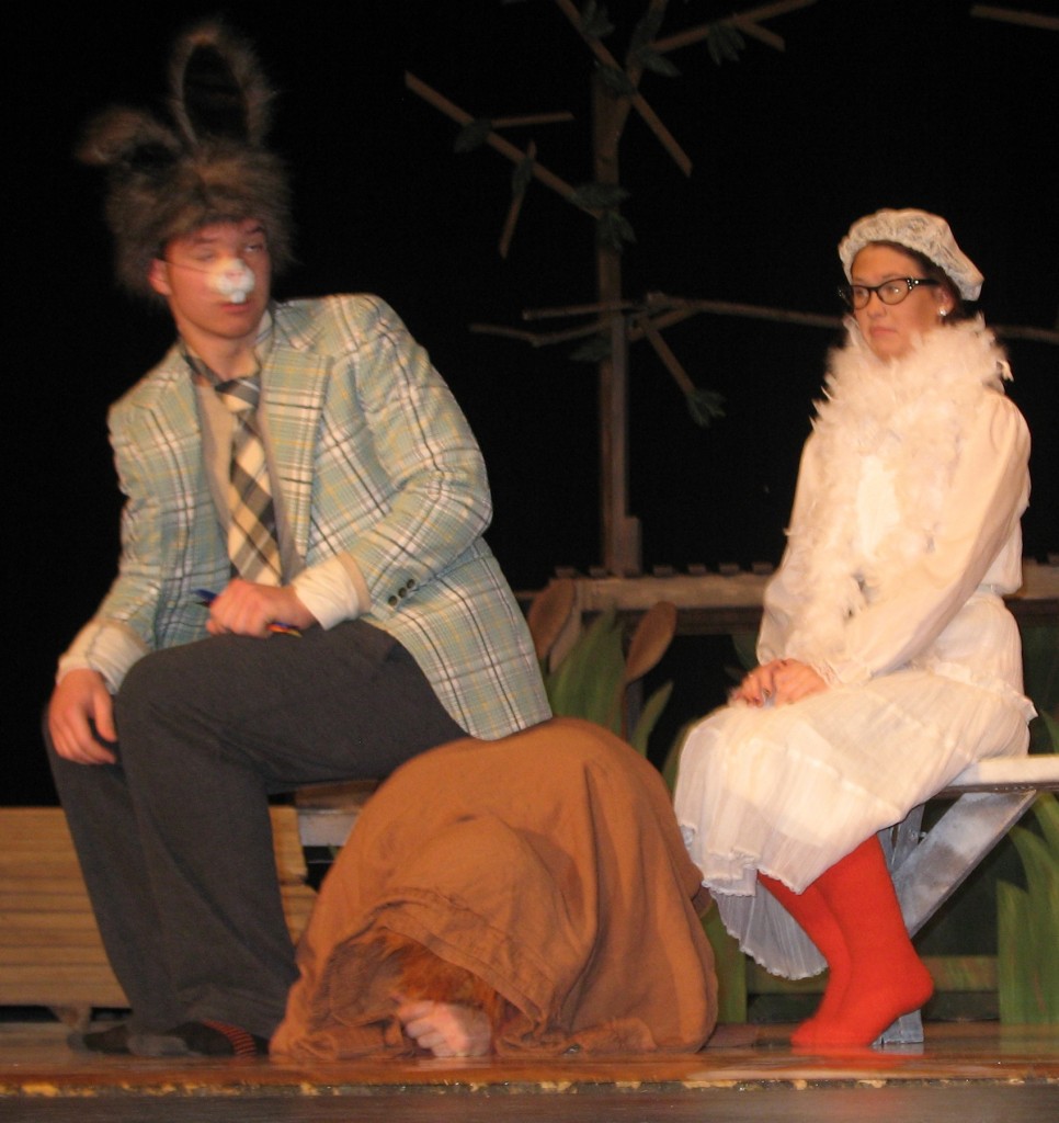 BRER RABBIT (BEN Grev), left, sits down for a chat with Miss Goose (Olivia Hopwood), right, not realizing the "moving laundry" he is perched on is really Brer Fox (Josh Grev), hidden under a big brown sack.