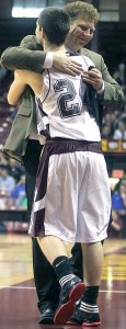 COACH SHAWN NAAS hugs Wolverine boys basketball player Andrew Hempeck during state tourney play in 2012. (Daily Globe photo)