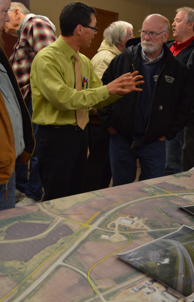 PETER HARFF, PROJECT Manager for Highway 60 at Bingham Lake, discussed another option - wider sjpace between westbound and eastbound lanes - with Country Pride Cooperative Manager Kevin Jackson, right.