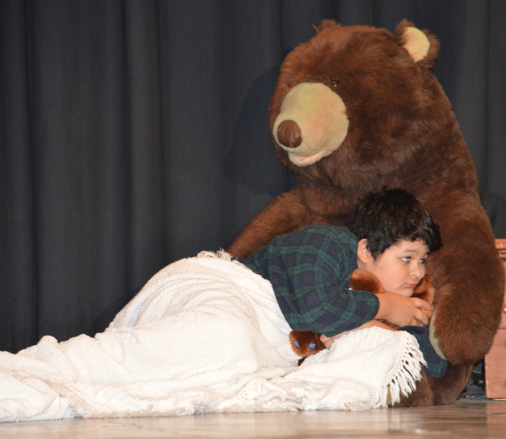 MICHAEL DARLING (DEVON Aguilar), tucked into his big bear bed, is supposed to be sleeping, but instead, is intently listening the conversation between Peter Pan, Tinkerbell and his sister, Wendy.