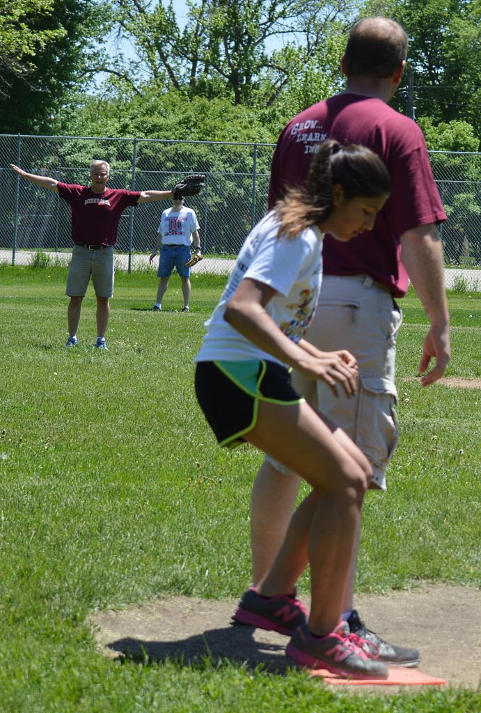 "SHE'S SAFE!" Sixth-grade teacher Kyle Blomgren's arm motions verify that fact as sixth-grader Janessa Johnson sneaks onto first base behind the first baseman, MLES Principal Karl Wassman.