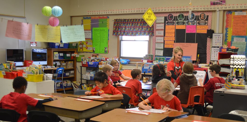 THE "ROAD" SIGN hanging from the ceiling declares "Kids At Work" - and this photo from math instruction time displays some of the differentiated. For the last two years, Kristine Friesen has been teaching math using thei Daily 3 Math Concept devised by The 2 Sisters, teachers (and sisters) Gail Boushey and Joan Moser. Students are able to work at their own levels - and receive immediate feedback on their learning. Through both the reading and math concepts, students are able to learn in small groups, experience multiple learning styles, move to reset the brain - and practice higher order thinking.