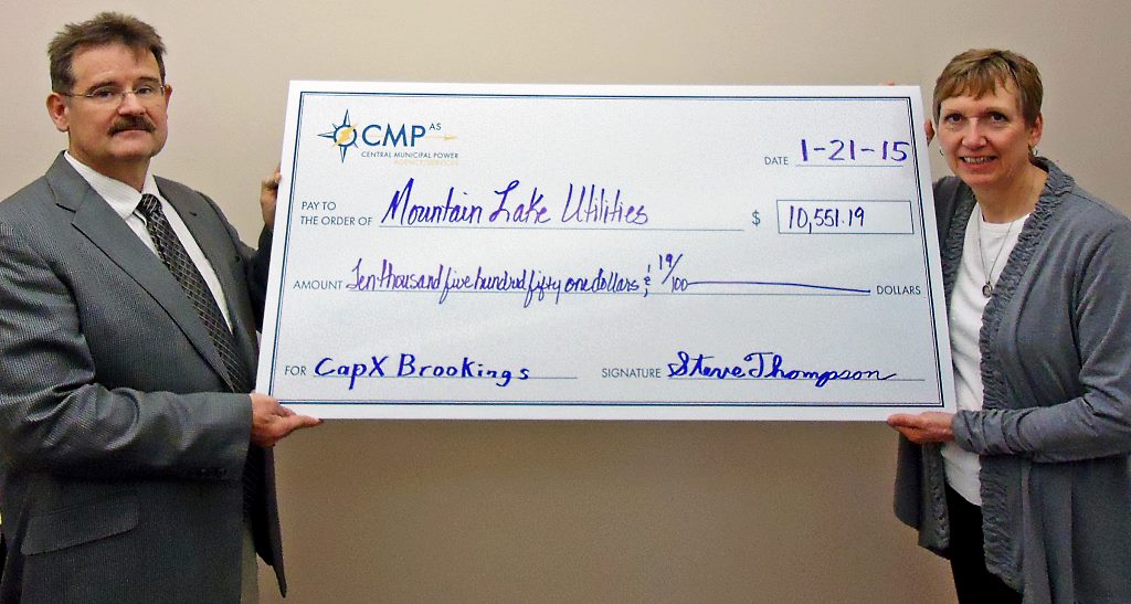    Photo Tagline: Steve Thompson, CEO of Central Minnesota Municipal Power Agency presents  Wendy Meyer, Mountain Lake City Administrator and newly-elected President of CMMPA, a  ceremonial check for participating in the CMMPA CAPX Brookings transmission investment  project that will help stabilize transmission rates for the city’s electric consumers.    