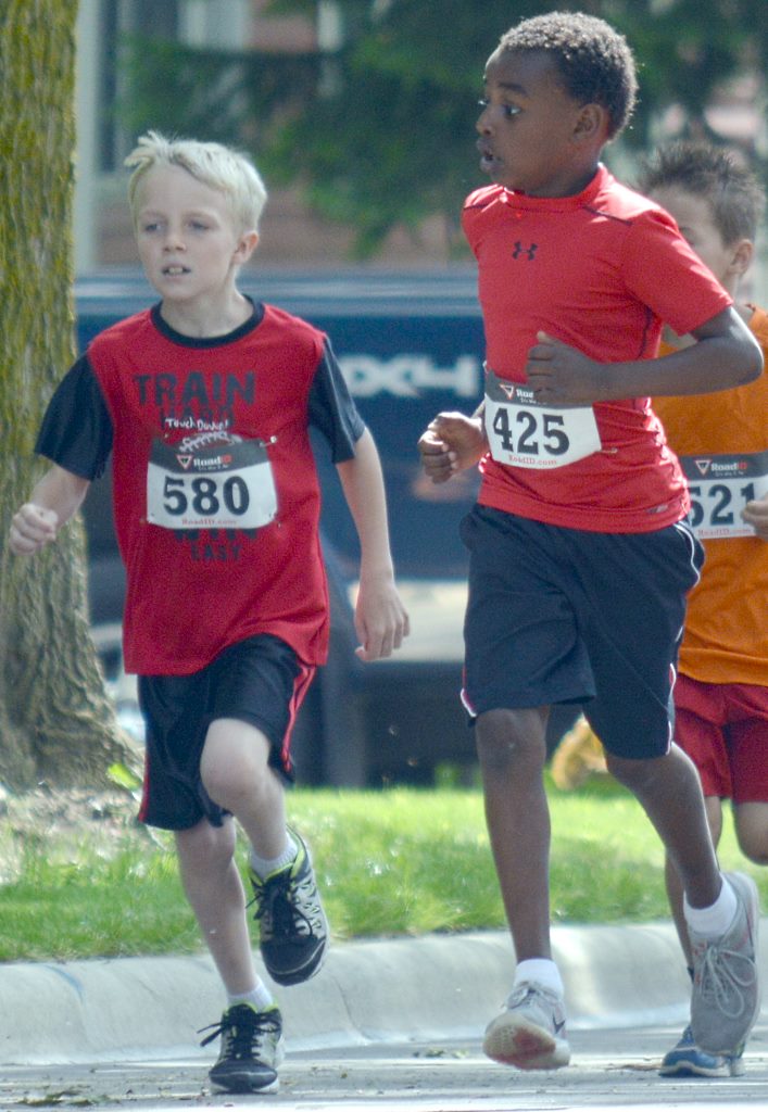 THE FIRST TWO runners across the finish line in the Kids 1/2 Mile Run (Up to Age 9). Coming in first was ??? Holmberg, right, with Sawyer Carrison, left, finishing second.