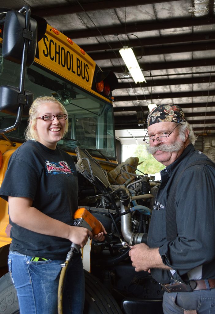 THE INNER-WORKINGS of cars (and buses) is her thing, and MLHS senior Breanna Lidtke, left, was Barney Wall's shadow at Town's Edge Auto of Mountain Lake on Tuesday, October 6.